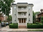 1119 Monroe St NE, a pale green house with stacked porches